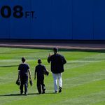 Andy Petitte and his sons walk across the outfield to the bullpen before today's game against the Orioles.